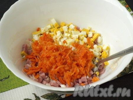 Очищенные яйца нарезать кубиками, морковь натереть на тёрке и добавить их в салат к ветчине и рису.
