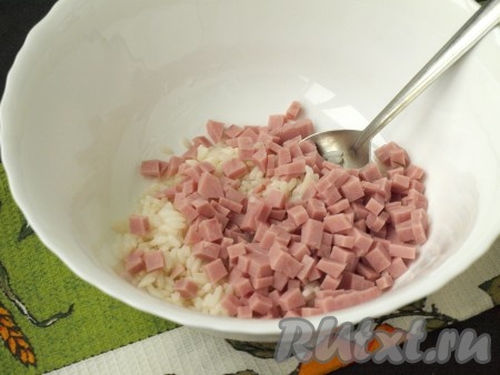 Отварной рис выложить в миску, добавить к нему нарезанную кубиками ветчину.
