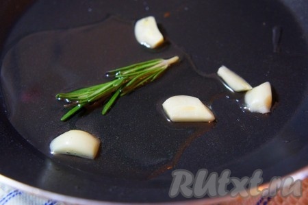 Очищенный чеснок нарежьте на пластины. Масло нагрейте на сковороде, выложите пластины чеснока и розмарин, прогрейте 1-2 минуты на среднем огне. Затем уберите чеснок и розмарин со сковороды. Ароматное масло для жарки свиных стейков на кости готово!
