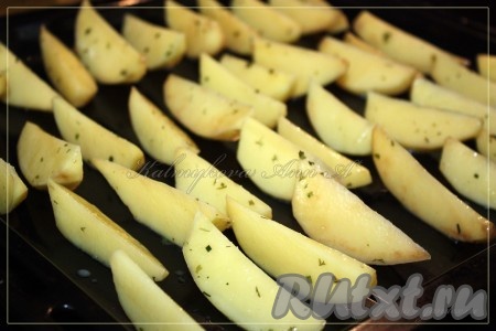 Выложить картофель на противень и поставить в духовку, разогретую до 180 градусов, на 30 минут.
