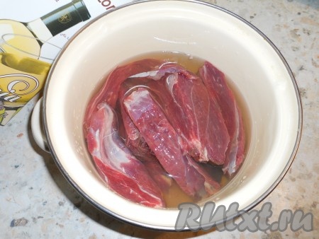 Мясо нужно срезать с кости, затем острым ножом тщательно зачистить от пленок и жира. Нарезать мясо кусками, поместить в кастрюлю, залить белым сухим вином. Оставить мясо на 1,5 часа.
