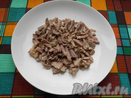 Мясной салат выкладывается слоями на плоскую тарелку. Продукты разделить на 2 части. Первым слоем выложить нарезанную кусочками отварную свинину.
