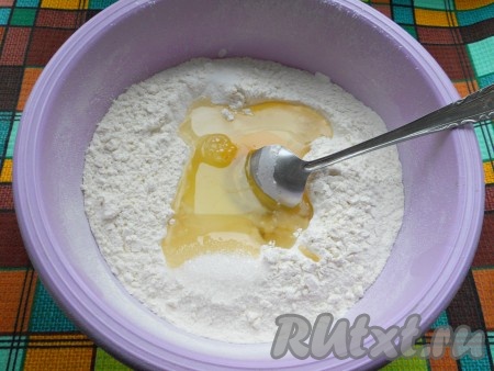 Муку просеять, сделать углубление. В него добавить яйцо, подсолнечное масло, соль и сахар, немного смешать с мукой.