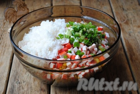 Мелко нарезанный зелёный лук и остывший рис выложить в крабовый салат. 
