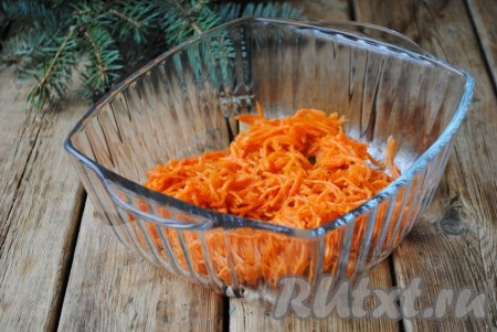 Морковь по-корейски отжать от сока и, если она натёрта очень длинной соломкой, нарезать её и выложить в салатницу.
