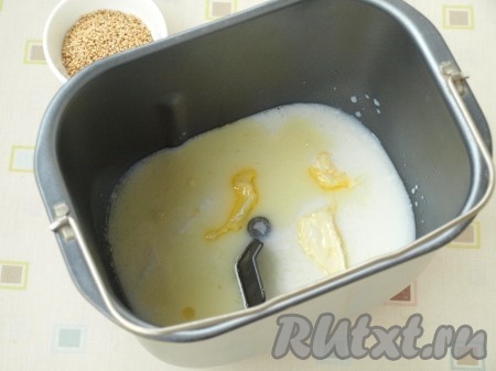 Немного подогреваем кефир. Подогретый кефир, подсолнечное и сливочное масло выливаем в форму хлебопечки, добавляем мёд.