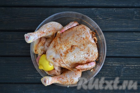 Лимон хорошо вымыть и разрезать на 2 части. Половинку лимона выложить в куриное брюшко. Миску с курицей накрыть пищевой пленкой и оставить в холоде, минимум, на 3 часа. За это время следует перевернуть курицу 2-4 раза.