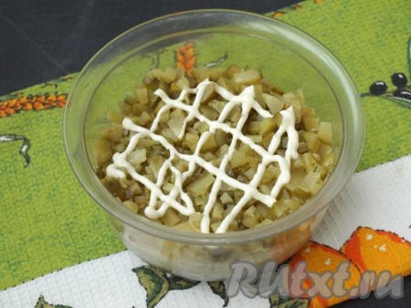 Нарезать кубиком маринованные огурчики и выложить сверху картофеля, смазать майонезом.
