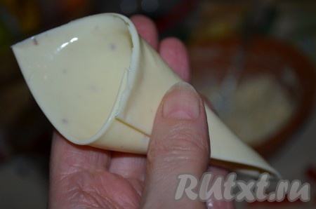 Сыр в пластине освободить от пленки, свернуть кулечком аккуратно.
