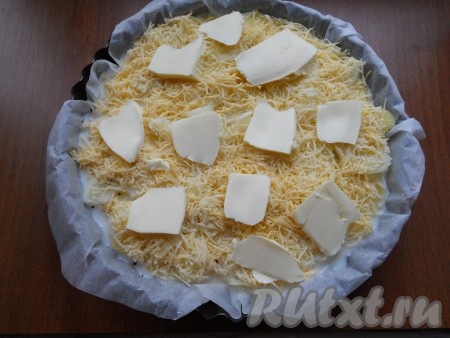 Сыр натереть на средней или мелкой терке и засыпать им верхний слой картофеля. Сверху разложить кусочки сливочного масла.
