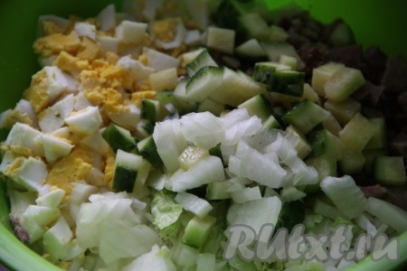 Огурец и очищенный лук нарезаем кубиками и отправляем в миску с салатом.
