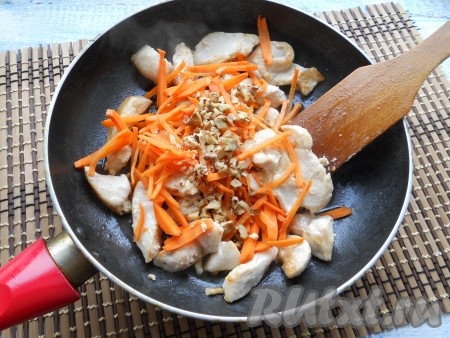 Добавить в сковороду к куриному филе нарезанную соломкой или натертую на крупной терке морковь и измельченные орехи, все посолить.
