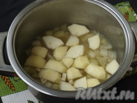 Яблоко очистить от кожуры, удалить сердцевину и произвольно нарезать. Также нарезать очищенный чеснок. Когда картошка сварится, добавить в суп яблоки и чеснок, варить 5 минут.
