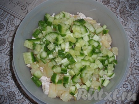 Свежий огурец нарезать мелкими кубиками и добавить в салат из ананасов и курицы.
