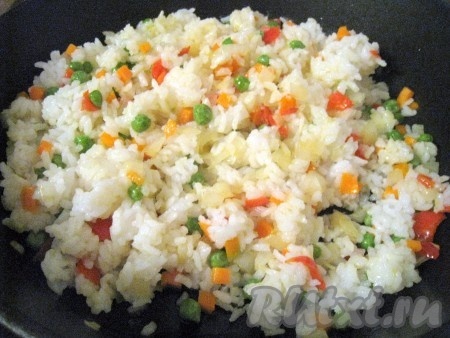 Рис перемешать с овощами на сковороде и оставить на слабом огне.