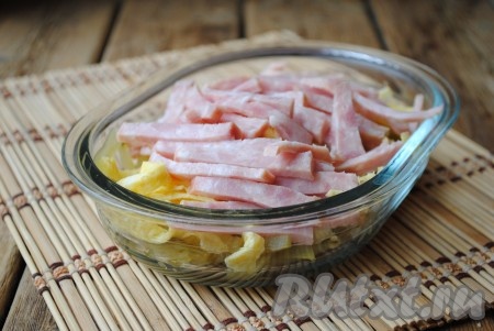 Колбасу освободить от плёнки, нарезать соломкой и добавить в салат с яичными блинчиками. 