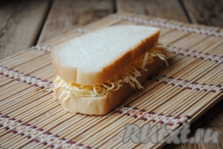 Сверху сыр накрыть вторым ломтиком хлеба. 

