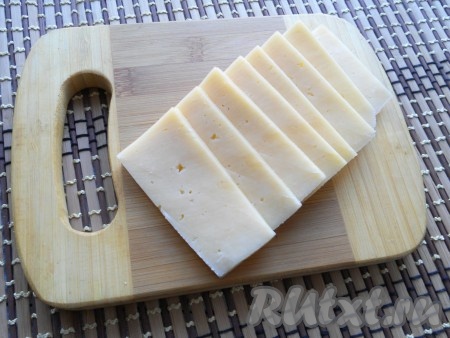 Твердый сыр нарезать ломтями толщиной около 0,5 см.
