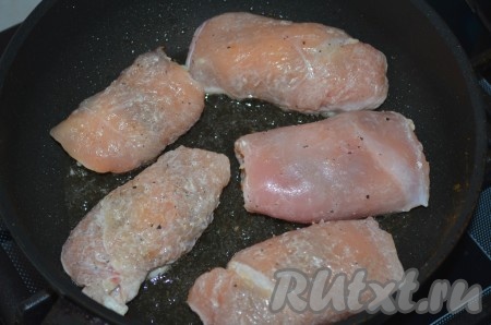 В сковороде разогреть масло, выложить куриные рулетики с начинкой из чернослива и сыра, жарить 3-4 минуты на сильном огне с одной стороны. 