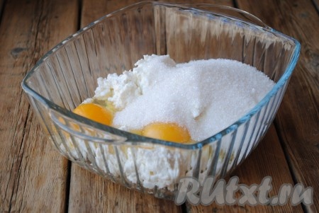 К творогу и яйцам всыпать сахар. По желанию можно добавить ванильный сахар.

