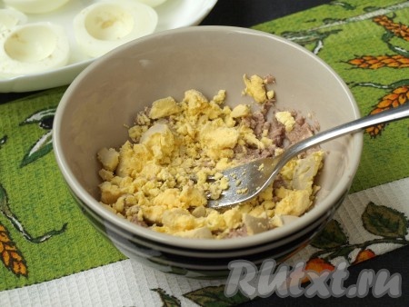 Из половинок яиц извлечь желтки, добавить их к печени трески и растереть всё вместе. В процессе можно добавить 2-3 чайных ложки масла от печени, чтобы масса не была сухой и легко формировалась.
