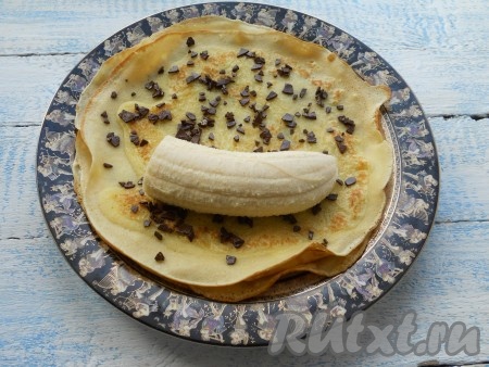 На верхний (третий) блинчик, посыпанный шоколадом, поместить половину банана.
