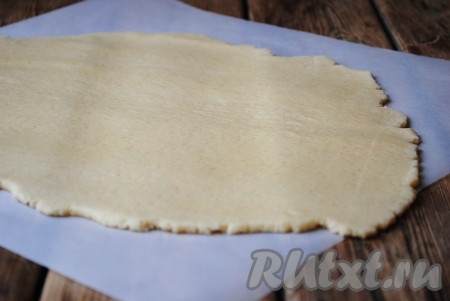 Подготовленное тесто раскатать в пласт толщиной 3-4 мм. Раскатывать удобно или сразу на пергаменте, или на столе, притрушенном мукой. 