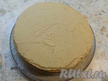 Сверху накрыть второй частью бисквита, немного придавить и смазать верх и бока торта оставшимся кремом. Выровнять. Поместить торт в холодильник на 5-8 часов.