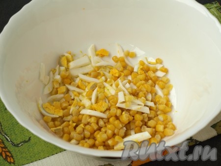 Сварить яйца, очистить, нарезать соломкой. Добавить к нарезанным яйцам консервированную кукурузу без жидкости.
