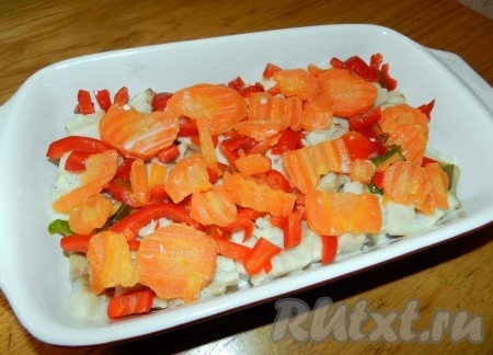 В форму для выпечки выложить рыбу, морковь и нарезанный болгарский перец.
