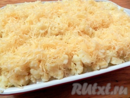 Сверху равномерно разложить картофельное пюре и посыпать натертым на терке сыром. 

