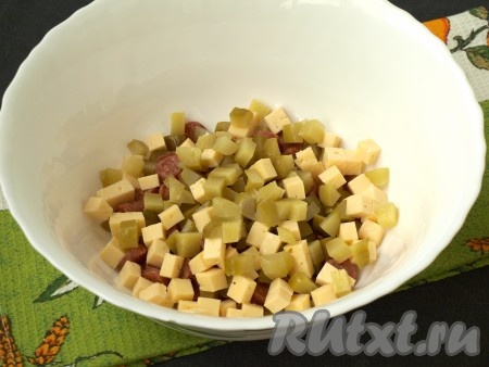 Кубиками нарезать маринованные огурчики и твёрдый сыр, добавить их к колбасе.

