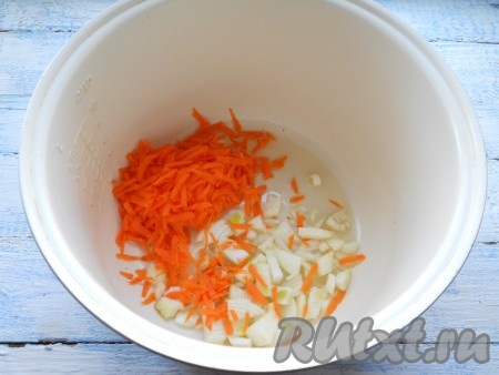 В чашу мультиварки налить растительное масло, выложить морковь, натертую на крупной терке, и нарезанный репчатый лук.