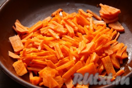 К обжаренному луку добавляем измельченную морковь и обжариваем около 5 минут, перемешивая.
