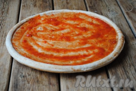 Основу для пиццы щедро смазать кетчупом. 
