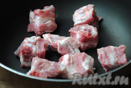 Свиные рёбрышки вымыть, обсушить и, нарезав на порционные кусочки, выложить на сковороду, разогретую с растительным маслом.
