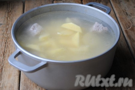 Когда свиные ребрышки сварятся (мясо станет мягким), выложить в кастрюлю картофель. Проварить суп после закипания на небольшом огне в течение 5-7 минут, затем добавить соль, чёрный молотый перец и лавровый лист.