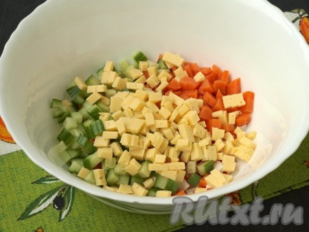 Твёрдый сыр и свежий огурец также нарезать кубиками и добавить в салат с крабовыми палочками и вареной морковью.
