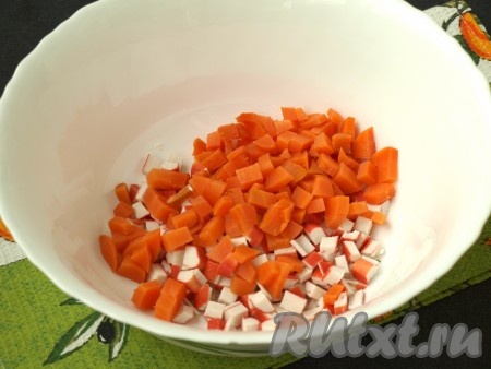Нарезать кубиками крабовые палочки и очищенную варёную морковь, сложить в миску.
