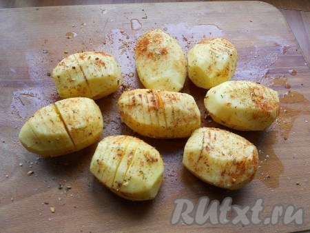 Картофель очистить, сделать надрезы на каждой картофелине не до конца (в виде картошки-гармошки). Посолить картофель, посыпать специями, травами и паприкой.
