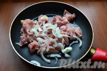 Мясо курицы нарезать кусочками, поместить в разогретую с растительным маслом сковороду. Добавить нарезанный тонкими полукольцами репчатый лук.