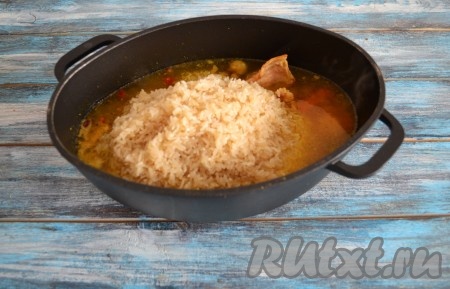 Выложить промытый рис к кусочкам кролика, тушеного с овощами.
