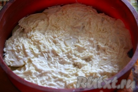 Оставшийся картофель натереть на мелкой терке, к нему добавить натертый сыр и сметану, перемешать и равномерно распределить полученную массу поверх кружочков картошки.
