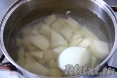 Картофель очистить и нарезать кубиками, залить водой и добавить целую луковицу. Отправить кастрюлю на огонь, после закипания снизить огонь до минимума и варить до готовности картошки.
