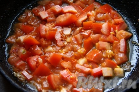 Болгарский перец очищаем от семян и плодоножки. Очищаем зубчики чеснока. На отдельной сковороде на растительном масле на среднем огне обжариваем в течение 5 минут, помешивая, мелко нарезанные помидоры.