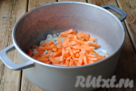 Лук и морковь очистить и вымыть. Лук нарезать кубиками, морковь - брусочками. В глубокую сковороду или, как в моём случае, казан влить растительное масло и выложить лук и морковь. Отправить на огонь и, периодически помешивая, жарить овощи 2-3 минуты.
