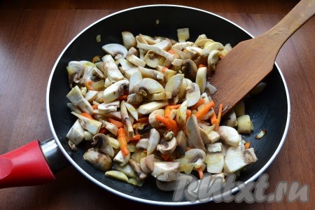 Лук с морковью обжарить в течение 5 минут, иногда помешивая, после чего добавить в сковороду шампиньоны. Обжаривать все вместе, помешивая, на небольшом огне еще минут 7-10.
