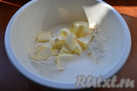 Для приготовления теста в просеянную муку добавить соль, сахар и нарезанное кусочками холодное сливочное масло.

