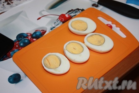 Вареные яйца аккуратно очистить от скорлупы и разрезать пополам. Желтки выложить в отдельную посуду.
