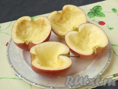 Разрезать пополам яблоки, вырезать сердцевины, оставляя стеночки толщиной около 5 мм. Сбрызнуть яблоки внутри лимонным соком.
